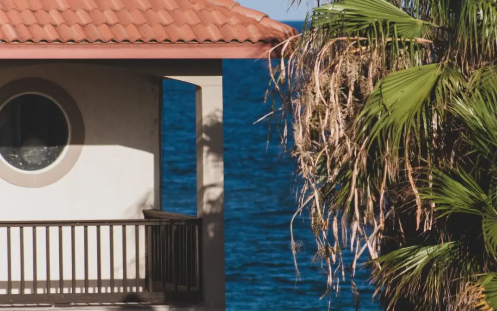 Terracotta tile roof on a waterfront home with palm trees
